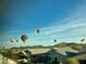 Hot air balloons over houses and desert mountains at 518 E Balao Dr, Phoenix, AZ 85085