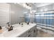 Modern bathroom with double vanity, gray cabinets, and blue and white striped shower curtain at 518 E Balao Dr, Phoenix, AZ 85085