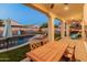 Covered patio with wooden dining table, chairs, and a view of the pool at 518 E Balao Dr, Phoenix, AZ 85085