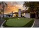 Sunset view of backyard featuring putting green and pool at 6131 E Kings Ave, Scottsdale, AZ 85254