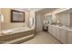 Luxurious bathroom with double vanity, soaking tub, and tiled walls at 7500 E Mccormick Pkwy # 78, Scottsdale, AZ 85258