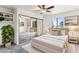 Well-lit bedroom with neutral tones, plush carpet, and large mirrored closet doors reflecting the bed and window at 7777 E Main St # 228, Scottsdale, AZ 85251