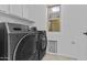 Convenient laundry room featuring modern Samsung washer/dryer units and a bright window at 7804 W Pershing Ave, Peoria, AZ 85381