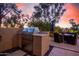 Outdoor kitchen featuring stainless steel grill, countertop space and covered dining area with sunset views at 7878 E Gainey Ranch Rd # 41, Scottsdale, AZ 85258