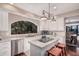 Bright kitchen featuring a center island cooktop and a large arched window at 7878 E Gainey Ranch Rd # 41, Scottsdale, AZ 85258