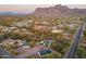 Aerial view of a property with multiple buildings, desert landscape, and mountains in the background at 831 N Arroya Rd, Apache Junction, AZ 85119