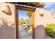 Ornate wooden gate opening to a desert garden at 8375 E Via Dona Rd, Scottsdale, AZ 85266