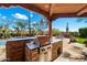 Outdoor kitchen with built-in grill, brick design, and scenic views at 8375 E Via Dona Rd, Scottsdale, AZ 85266