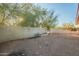 Backyard view with a dirt area, wall, and sparse vegetation at 843 N Arroya Rd, Apache Junction, AZ 85119