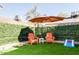 Private backyard with two orange Adirondack chairs and a putting green at 8520 W Palm Ln # 1049, Phoenix, AZ 85037