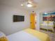 Spacious bedroom with mounted TV and yellow bedding at 8520 W Palm Ln # 1049, Phoenix, AZ 85037