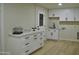 Clean laundry room with white cabinets and a utility sink at 10301 W Cheryl Dr, Sun City, AZ 85351