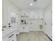 Bright laundry room with white cabinets and modern finishes at 10301 W Cheryl Dr, Sun City, AZ 85351