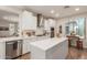 Modern kitchen with white cabinets, stainless steel appliances, and an island at 10496 W Cottontail Ln, Peoria, AZ 85383