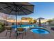 Relaxing pool area with lounge chairs and umbrellas at 10496 W Cottontail Ln, Peoria, AZ 85383