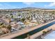 Aerial view showing a house with a backyard, artificial turf, and a fire pit near a canal at 1152 W Greenway Dr, Tempe, AZ 85282