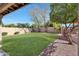 Landscaped backyard with a grassy area and covered patio at 11553 N 76Th Dr, Peoria, AZ 85345