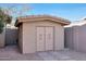 Tan storage shed with double doors in the backyard at 11553 N 76Th Dr, Peoria, AZ 85345