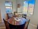 Cozy dining area with a wooden table and chairs, illuminated by natural light from the windows at 12075 E Chevelon Trl, Gold Canyon, AZ 85118