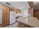 Galley style kitchen with wood cabinets and white appliances at 1231 E Vine Ave, Mesa, AZ 85204