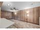 Living room boasts wood paneled walls and neutral carpeting at 1231 E Vine Ave, Mesa, AZ 85204