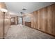 Spacious living room with wood paneled walls and a view of the kitchen at 1231 E Vine Ave, Mesa, AZ 85204