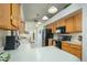 Kitchen with wood cabinets, black appliances, and tile floor at 12323 W Tigerseye Dr, Sun City West, AZ 85375