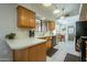 View of kitchen with wood cabinets, black appliances and tile floors at 12323 W Tigerseye Dr, Sun City West, AZ 85375