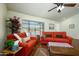 Bright living room with orange couches and hardwood floors at 12323 W Tigerseye Dr, Sun City West, AZ 85375