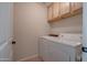 Laundry room with washer, dryer, and overhead cabinets at 1397 E Cheyenne St, Gilbert, AZ 85296