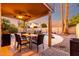 Covered patio area with dining table and chairs for outdoor entertaining near the pool at 1540 W Orchid Ln, Chandler, AZ 85224