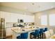 Modern kitchen with granite island, white cabinets, and gold lighting at 15541 S 181St Ln, Goodyear, AZ 85338