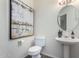 Clean bathroom with a pedestal sink, toilet, and large art piece at 16614 N 51St St, Scottsdale, AZ 85254