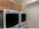 Bright laundry room, washer, dryer, and cabinets at 16614 N 51St St, Scottsdale, AZ 85254