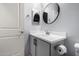 Clean bathroom with a vanity and large round mirror at 17215 W Molly Ln, Surprise, AZ 85387