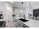 Modern kitchen with gray cabinets, a large island, and black sink at 17215 W Molly Ln, Surprise, AZ 85387