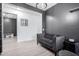 Small sitting area with gray walls, wood-look floors, and a dark couch at 17215 W Molly Ln, Surprise, AZ 85387