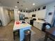 Modern kitchen with white cabinets, island, and dining area at 17256 W West Wind Dr, Surprise, AZ 85387