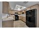 Modern kitchen with black appliances and light wood cabinets at 17404 N 99Th Ave # 205, Sun City, AZ 85373