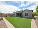 Artificial turf backyard with hot tub and covered patio at 18370 W Goldenrod St, Goodyear, AZ 85338