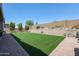 Landscaped backyard featuring artificial turf and brick pavers at 18370 W Goldenrod St, Goodyear, AZ 85338