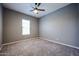 Bright and airy bedroom with plush carpeting and ceiling fan at 18370 W Goldenrod St, Goodyear, AZ 85338