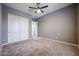 Well-lit bedroom featuring double door closet and ceiling fan at 18370 W Goldenrod St, Goodyear, AZ 85338