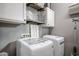 Convenient laundry room with washer, dryer, and overhead shelving at 18370 W Goldenrod St, Goodyear, AZ 85338