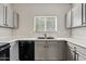 Cozy kitchen featuring gray cabinets, a double sink, and modern appliances at 1866 E Dust Devil Dr, San Tan Valley, AZ 85143