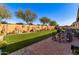 Landscaped backyard with artificial turf and a patio area at 18904 W Mercer Ln, Surprise, AZ 85388