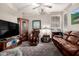 Relaxing living room featuring brown leather furniture and a large TV at 18904 W Mercer Ln, Surprise, AZ 85388