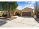 Tan stucco house with a brown garage door and mature tree in front at 20515 N 264Th Ave, Buckeye, AZ 85396