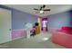 A stylish bedroom features a ceiling fan, a desk with a white board and pink accents at 20552 W Carlton Mnr, Buckeye, AZ 85396