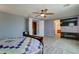 Open Primary bedroom featuring ceiling fan, wood floors, ensuite bathroom, and wall-mounted TV at 20552 W Carlton Mnr, Buckeye, AZ 85396